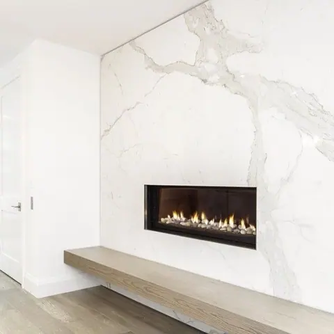 White marble with grey veining is used for the fireplace surround, alongside clean architectural lines and contemporary fittings.