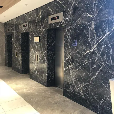Black marble with white veining is used for the feature wall, alongside clean architectural lines and contemporary fittings.