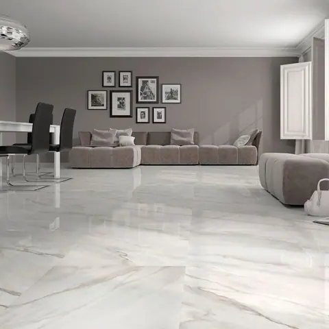 Light marble is used for the floor throughout the room, alongside comfortable seating and a restrained neutral palette. Broad pale surfaces give the minimally furnished room an open feel.